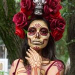 A striking Catrina portrait celebrating Dia de Muertos with vibrant makeup and floral decoration.