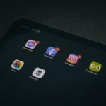 A tablet displaying popular apps like Facebook and Instagram in a dimly lit setting.