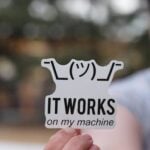 Person holding a humorous IT sticker outdoors, perfect for tech enthusiasts.