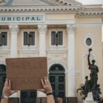 Crowd holding a sign 'MARIELLE PRESENTE' at Rio's city hall.