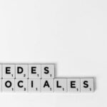 Scrabble tiles spelling 'Redes Sociales' illustrating a social media concept on a white background.